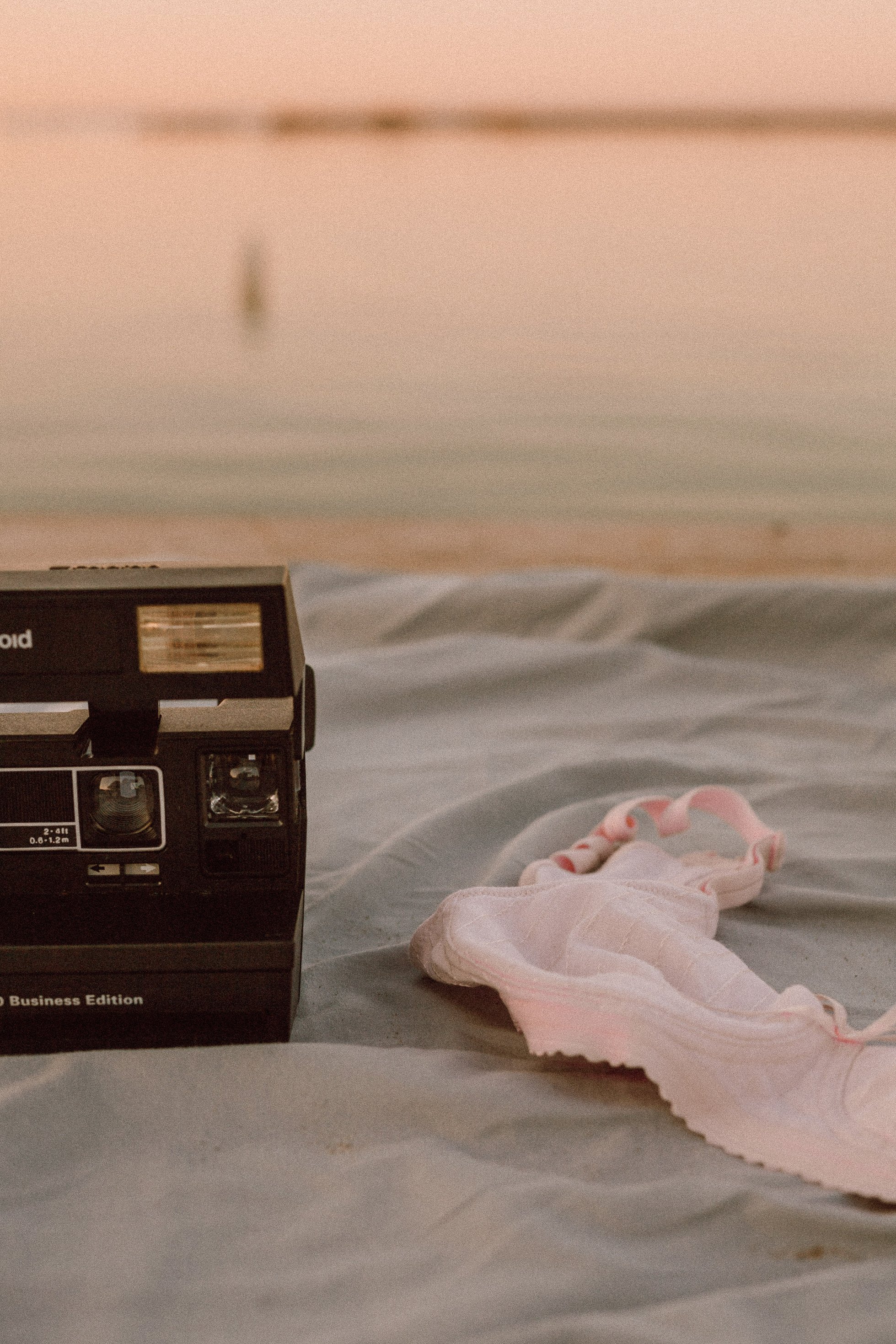 Polaroid Camera and Brassiere on Fabric at the Beach